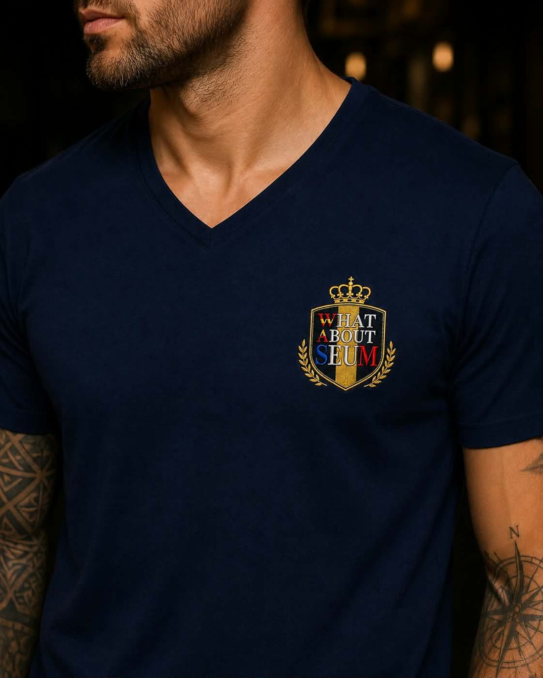 T-shirt bleu nuit col V avec le blason WHATABOUTSEUM brodé sur le cœur